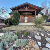 Thumbnail of http://Front%20exterior%20renovation%20at%20a%20brick%20house%20featuring%20a%20covered%20front%20porch%20and%20new%20landscaping.