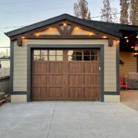 Thumbnail of http://One-car%20garage%20exterior%20with%20a%20concrete%20driveway%20and%20string%20lights%20hung%20above.
