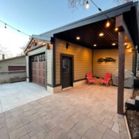Thumbnail of http://One-car%20garage%20exterior%20with%20a%20concrete%20driveway,%20covered%20patio%20on%20the%20side,%20and%20string%20lights%20hung%20above.