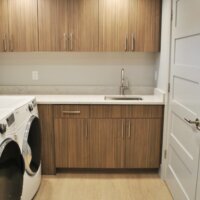 Thumbnail of http://Laundry%20room%20with%20washer%20and%20dryer%20side-by-side,%20a%20sink,%20and%20cabinetry.
