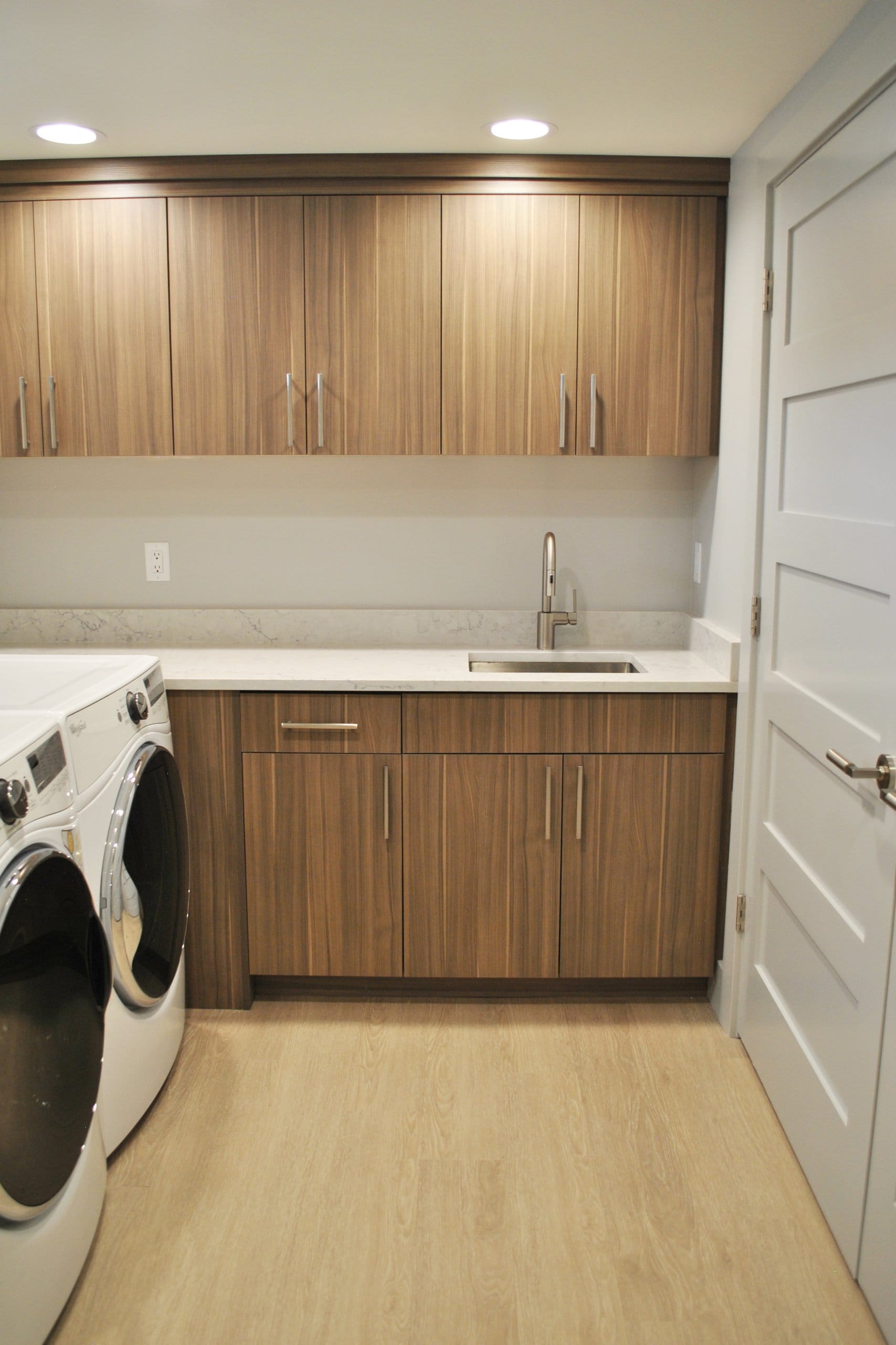 Laundry room with washer and dryer side-by-side, a sink, and cabinetry.