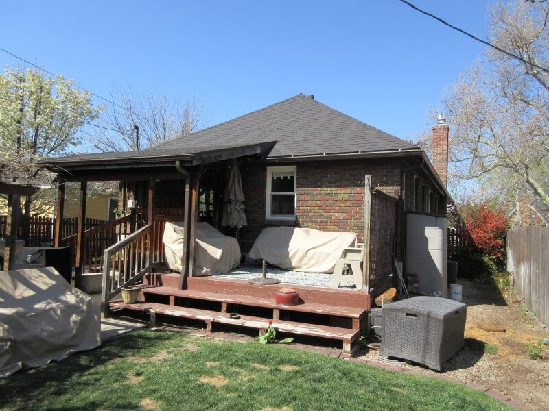 Exterior of the house before the addition with an old, partially covered deck.