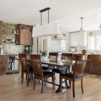 Thumbnail of http://Dining%20room%20with%20seating%20for%20six%20that%20is%20open%20to%20the%20kitchen.%20The%20space%20features%20a%20built-in%20bar%20with%20a%20green%20tile%20backsplash,%20dark%20wood%20cabinets,%20and%20a%20mini%20fridge.