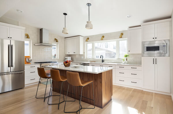 Kitchen addition that features a large island with seating for three in the center and a large window centered above the sink