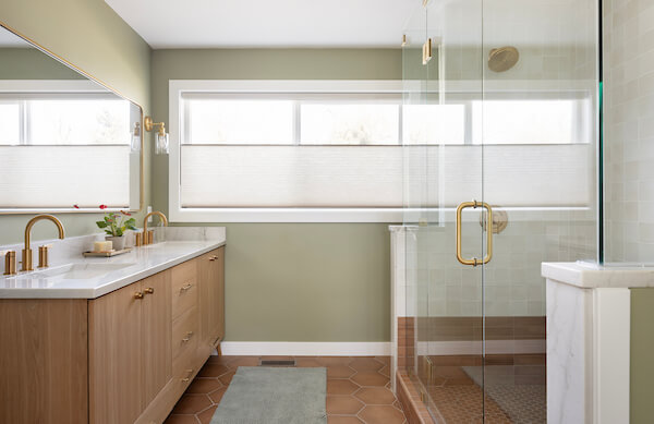 Primary bathroom with large window, double vanity, and shower.
