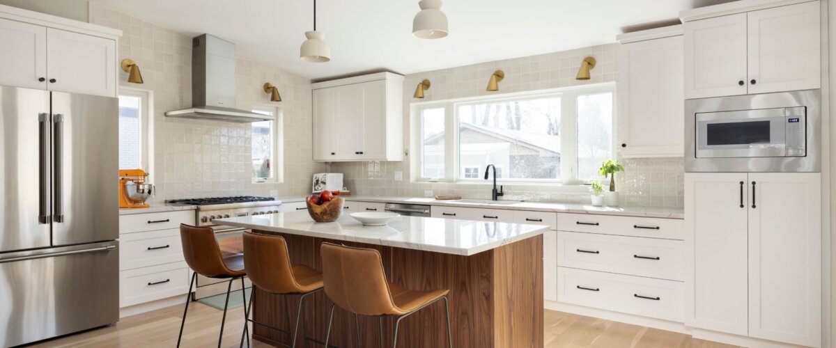 Kitchen addition that features a large island with seating for three in the center and a large window centered above the sink