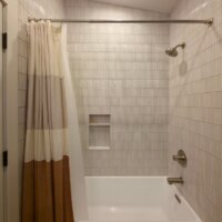 Thumbnail of http://Guest%20bathroom%20tub%20with%20a%20simple,%20elegant%20design.%20The%20combined%20tub%20and%20shower%20includes%20a%20niche.