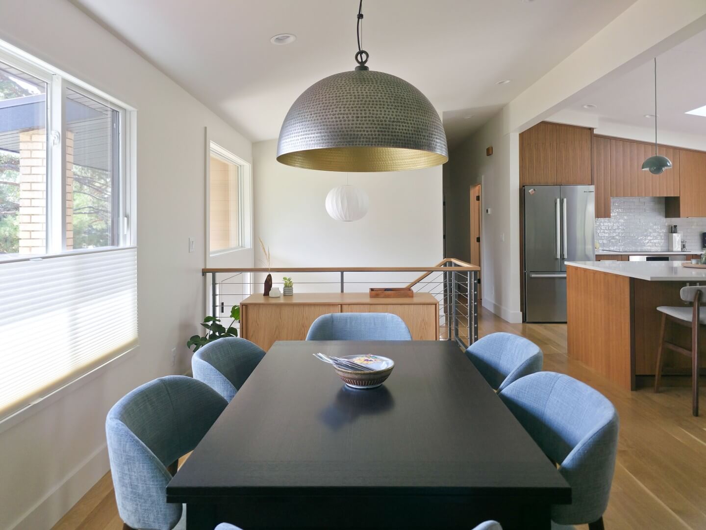 Open concept modern dining room design with a table for six centered under the light.