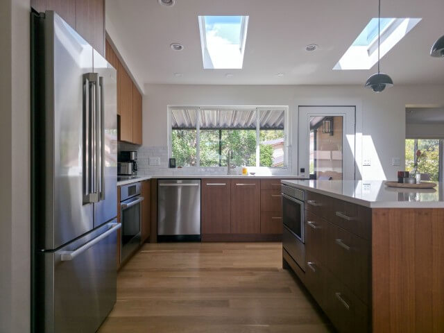 Mid-century modern kitchen renovation featuring vaulted ceilings and an island in the center.