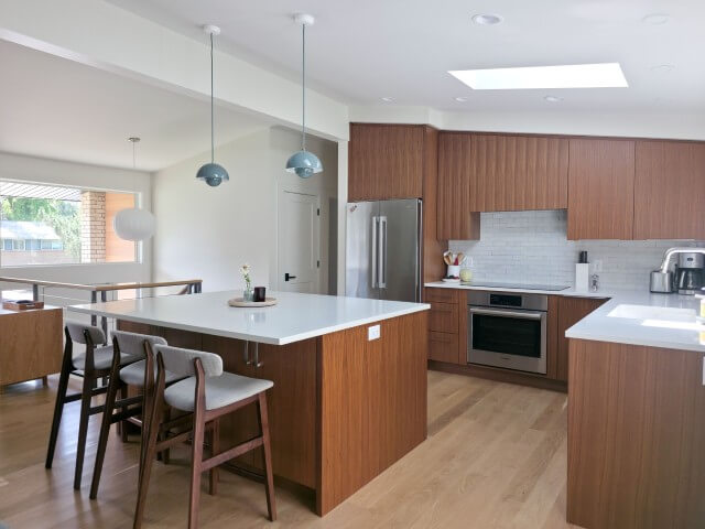 Mid-century modern kitchen renovation featuring vaulted ceilings and an island in the center.