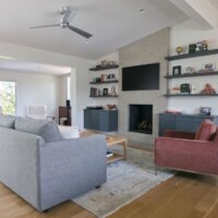 Thumbnail of http://Renovated%20living%20room%20in%20a%20mid-century%20modern%20design.%20The%20space%20features%20a%20fireplace%20with%20built-in%20shelves%20on%20either%20side.