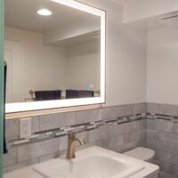 Thumbnail of http://Bathroom%20toilet%20and%20vanity%20with%20a%20mirror%20light%20centered%20above.