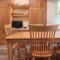 Thumbnail of http://Dining%20table%20with%20chairs%20and%20a%20cabinet%20behind.