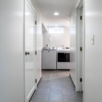 Thumbnail of http://Hallway%20leading%20to%20the%20laundry%20room%20with%20tile%20flooring%20and%20white%20walls.