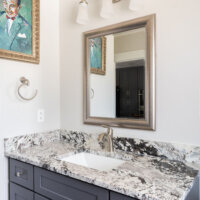 Thumbnail of http://Powder%20bathroom%20vanity%20with%20a%20mirror%20and%20light%20above.%20On%20the%20wall%20to%20the%20left,%20is%20a%20picture%20and%20a%20hook%20to%20hang%20a%20towel.