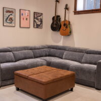Thumbnail of http://Basement%20family%20room%20couch%20with%20an%20ottoman%20in%20the%20center.