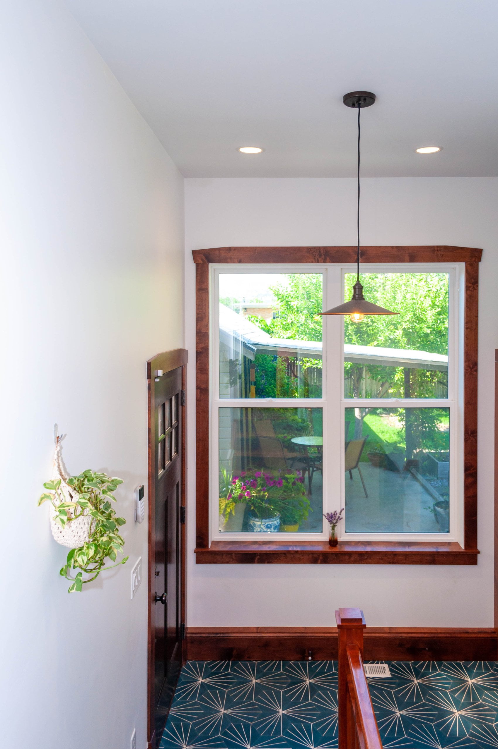Window in the mudroom with view of the backyard and a light centered above.