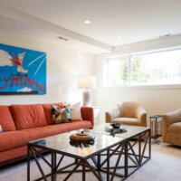 Thumbnail of http://Basement%20family%20room%20with%20a%20long%20window,%20couch,%20coffee%20table,%20and%20two%20chairs.