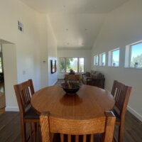 Thumbnail of http://Interior%20of%20the%20addition.%20The%20space%20includes%20vaulted%20ceilings,%20multiple%20windows,%20a%20table%20and%20chairs,%20and%20a%20couch%20with%20a%20rug%20in%20front%20of%20the%20TV.