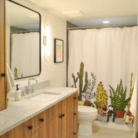 Thumbnail of http://Bathroom%20with%20a%20shower%20curtain%20hung,%20toilet,%20and%20large%20vanity%20with%20storage.