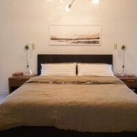 Thumbnail of http://Large%20bed%20with%20picture%20above%20and%20nightstands%20on%20either%20side.%20A%20light%20hangs%20in%20the%20center,%20above%20the%20bed,%20as%20well%20as%20from%20the%20wall%20above%20each%20nightstand.