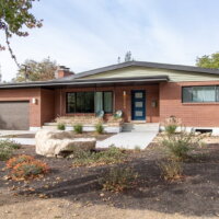 Thumbnail of http://The%20exterior%20of%20a%20ranch%20rambler%20style%20home%20after%20renovating%20the%20curb%20appeal.%20The%20brick%20home%20includes%20a%20covered%20front%20porch%20and%20two-car%20garage.%20In%20front,%20the%20updated%20landscaping%20includes%20a%20walk-way%20to%20the%20front%20door%20and%20various%20plants.