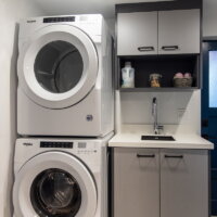 Thumbnail of http://Compact%20laundry%20room%20with%20stacked%20washer%20and%20dryer%20next%20to%20a%20sink%20with%20cabinetry%20above.