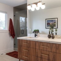 Thumbnail of http://Contemporary%20bathroom%20remodel%20with%20two%20sinks%20next%20to%20the%20shower.%20Above%20the%20sink%20is%20a%20large%20mirror%20that%20is%20reflecting%20the%20closet%20and%20a%20picture%20on%20the%20wall%20behind.%20On%20the%20wall%20to%20the%20left%20is%20a%20towel%20hanging%20from%20a%20hook%20and%20a%20window.