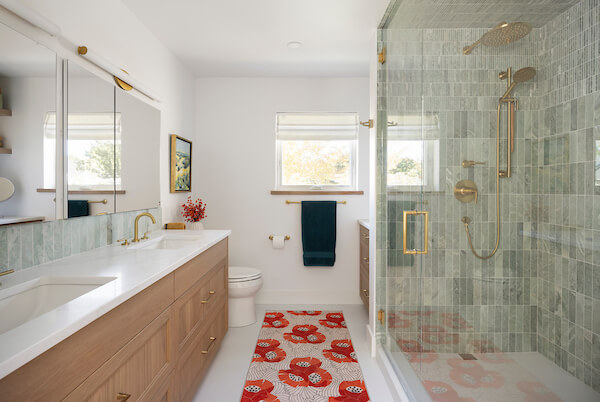 Primary bathroom with a double vanity, toilet, storage, and large shower.