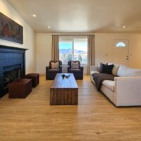 Thumbnail of http://Family%20room%20with%20couch,%20ottomans,%20two%20chairs,%20and%20coffee%20table%20in%20front%20of%20the%20window%20and%20fireplace.