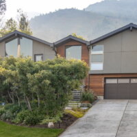 Thumbnail of http://Exterior%20home%20renovation.%20The%20home%20sits%20in%20front%20of%20a%20beautiful%20mountain%20backdrop%20and%20is%20partially%20hidden%20by%20the%20landscaping.