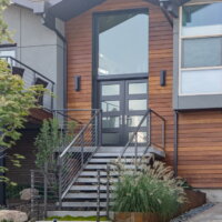 Thumbnail of http://Exterior%20of%20split%20level%20home%20after%20the%20renovation%20with%20a%20modern%20front%20door%20and%20a%20railing%20up%20to%20the%20front%20porch.