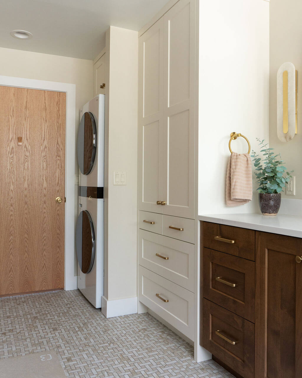 Primary bathroom with storage cabinet and stacked washer and dryer.