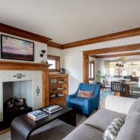 Thumbnail of http://Historic%20home%20living%20room%20with%20wood%20details%20in%20the%20trim,%20casing,%20and%20built-in%20bookshelves%20on%20either%20side%20of%20the%20fireplace.%20The%20entire%20room%20is%20open%20to%20the%20dining%20room%20through%20a%20cased%20opening,%20and%20the%20fireplace%20serves%20as%20a%20focal%20point%20with%20a%20beautiful%20tile%20surround.%20Home%20renovation%20architects.