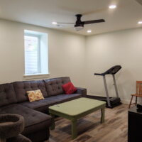 Thumbnail of http://Basement%20family%20room%20with%20couch,%20coffee%20table,%20and%20treadmill.