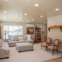 Thumbnail of http://Family%20room%20remodel%20with%20the%20two%20couches%20under%20the%20windows,%20bookcases,%20and%20chairs%20around%20the%20ottoman%20in%20the%20center.