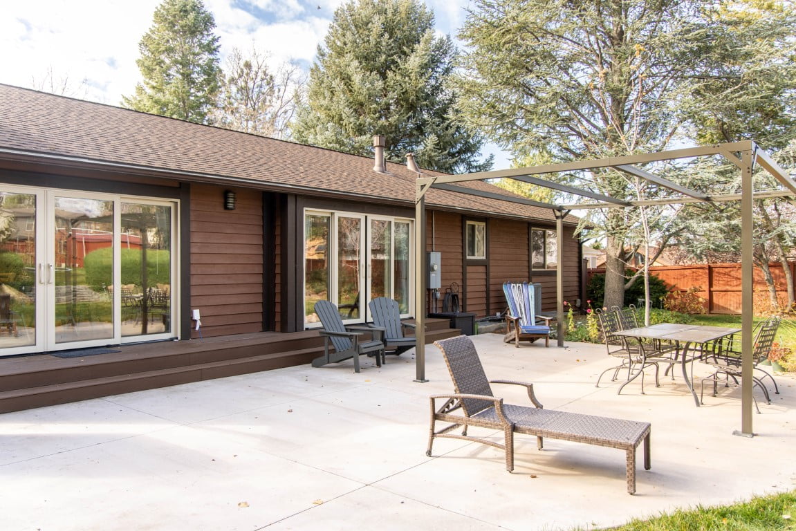 Backyard patio with outdoor furniture and a pergola structure.
