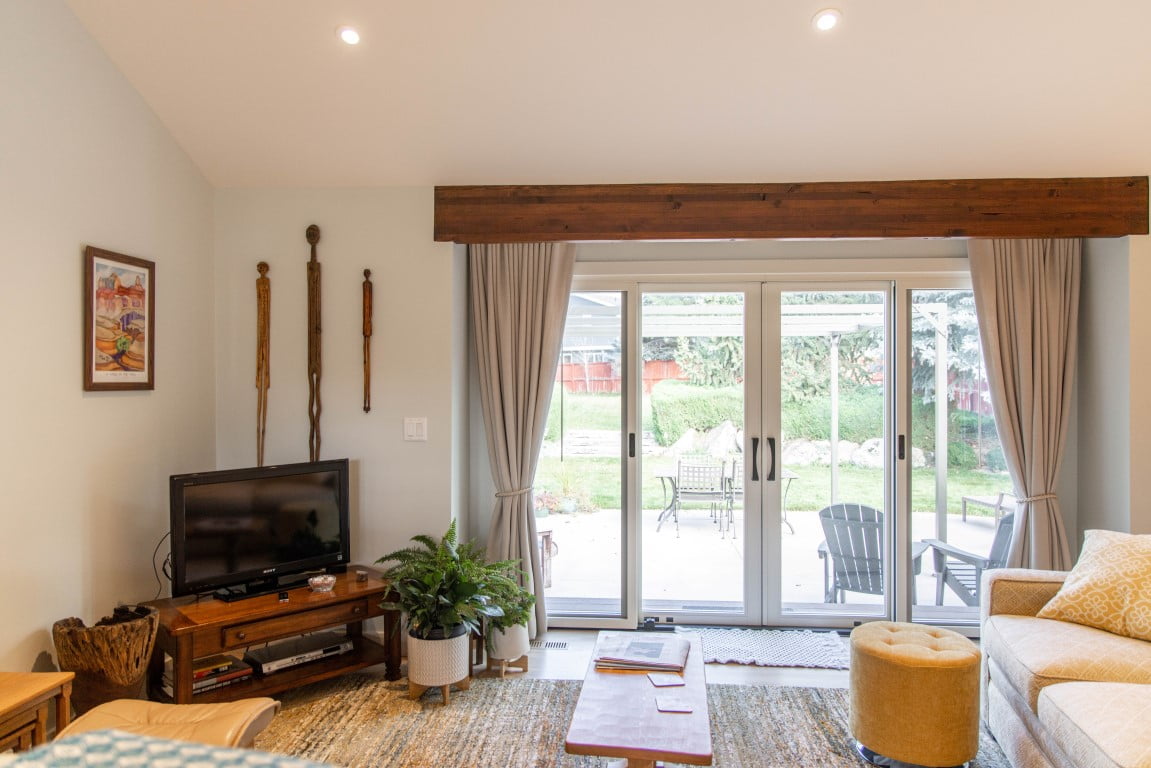 Family room with sliding doors to the patio, tall ceilings, and furniture.