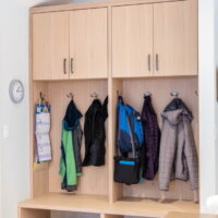 Thumbnail of http://Modern%20mudroom%20cabinetry.%20The%20cabinets%20include%20open%20spots%20for%20shoes%20at%20the%20bottom,%20a%20bench%20with%20coat%20hooks%20behind%20on%20the%20wall,%20and%20cabinets%20above.