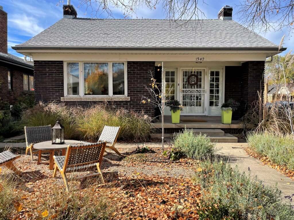 Front exterior of a bungalow home with brick and a covered front porch.