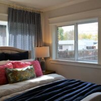 Thumbnail of http://Primary%20bedroom%20with%20a%20large%20bed,%20windows,%20and%20nightstands.