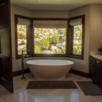 Thumbnail of http://Large%20free%20standing%20bath%20tub%20in%20a%20bay%20window.%20In%20front%20of%20the%20tub%20are%20two%20small%20bath%20mats%20with%20one%20being%20in%20front%20of%20the%20sink.%20Across%20from%20the%20sink%20is%20an%20open%20door.