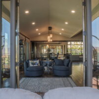 Thumbnail of http://View%20from%20the%20patio%20to%20two%20chairs%20and%20a%20side-table%20inside.