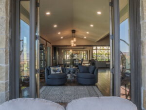 View from the patio to two chairs and a side-table inside.