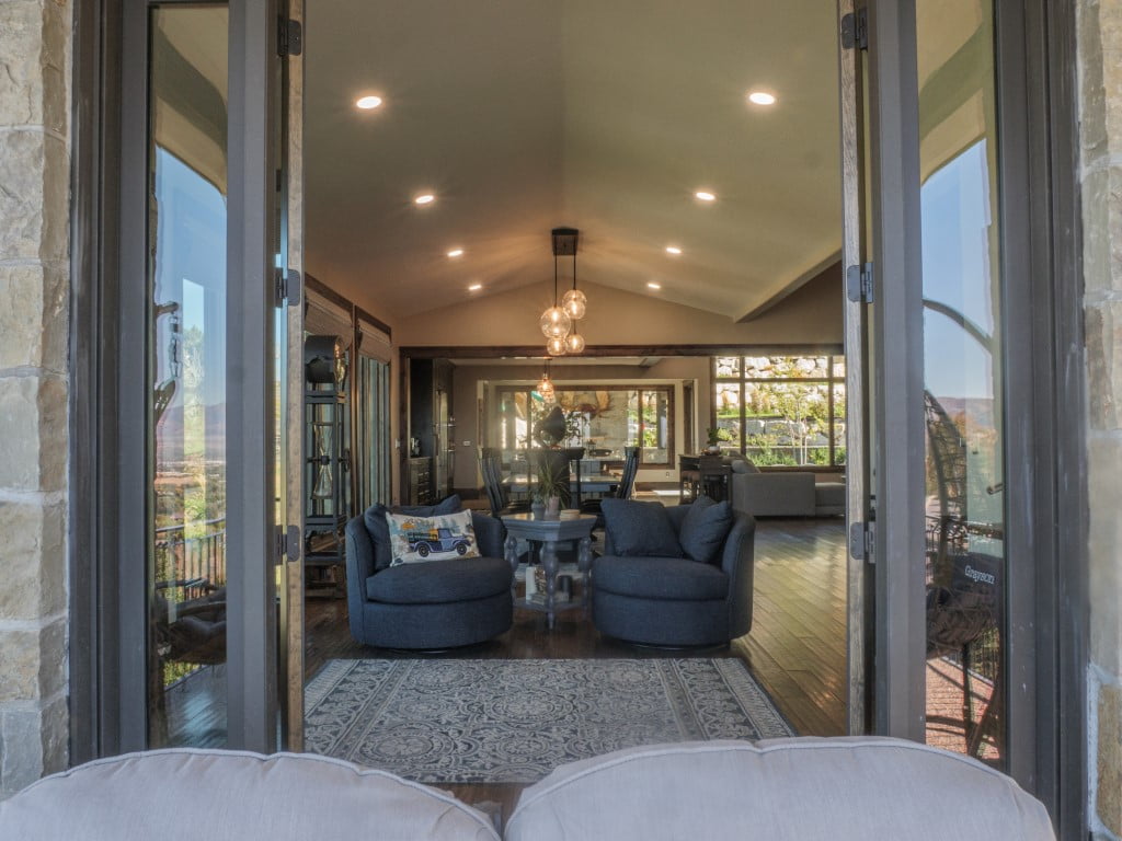 View from the patio to two chairs and a side-table inside.