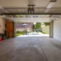 Thumbnail of http://Interior%20of%20two-car%20garage%20with%20door%20open%20looking%20out%20toward%20the%20driveway.