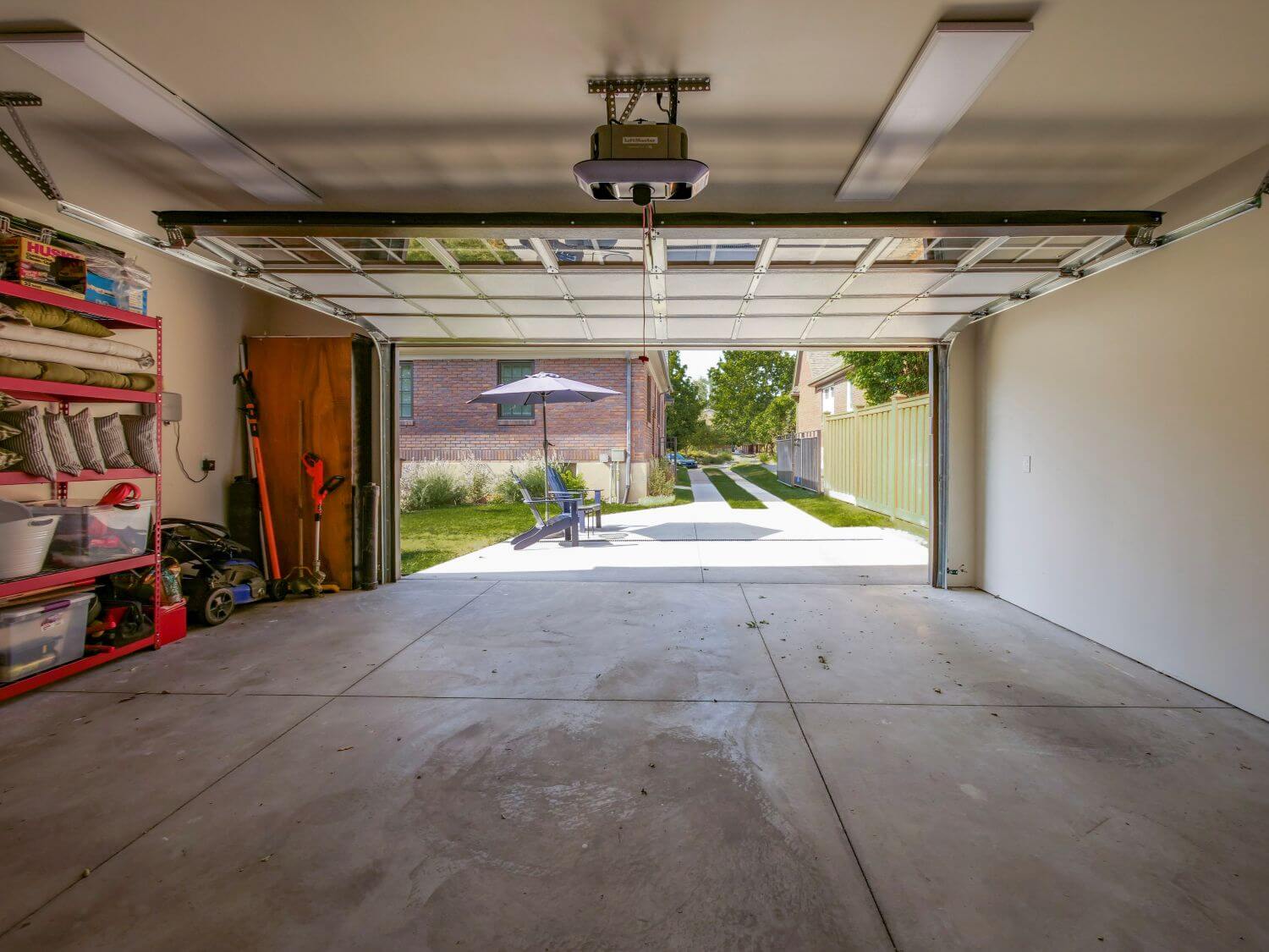 Interior of two-car garage with door open looking out toward the driveway.
