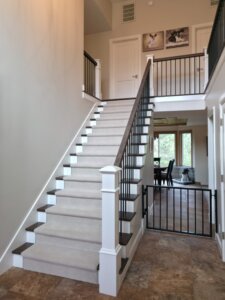 Entry into home with a staircase and dog gate that matches with the railing. Dog-friendly home design ideas.