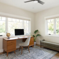 Thumbnail of http://Home%20office%20furnished%20with%20a%20desk,%20plants,%20and%20bench%20seat.