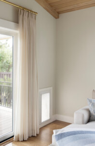 Interior of the dog door. The door is located next to some curtains and the couch. Dog-friendly home design ideas.
